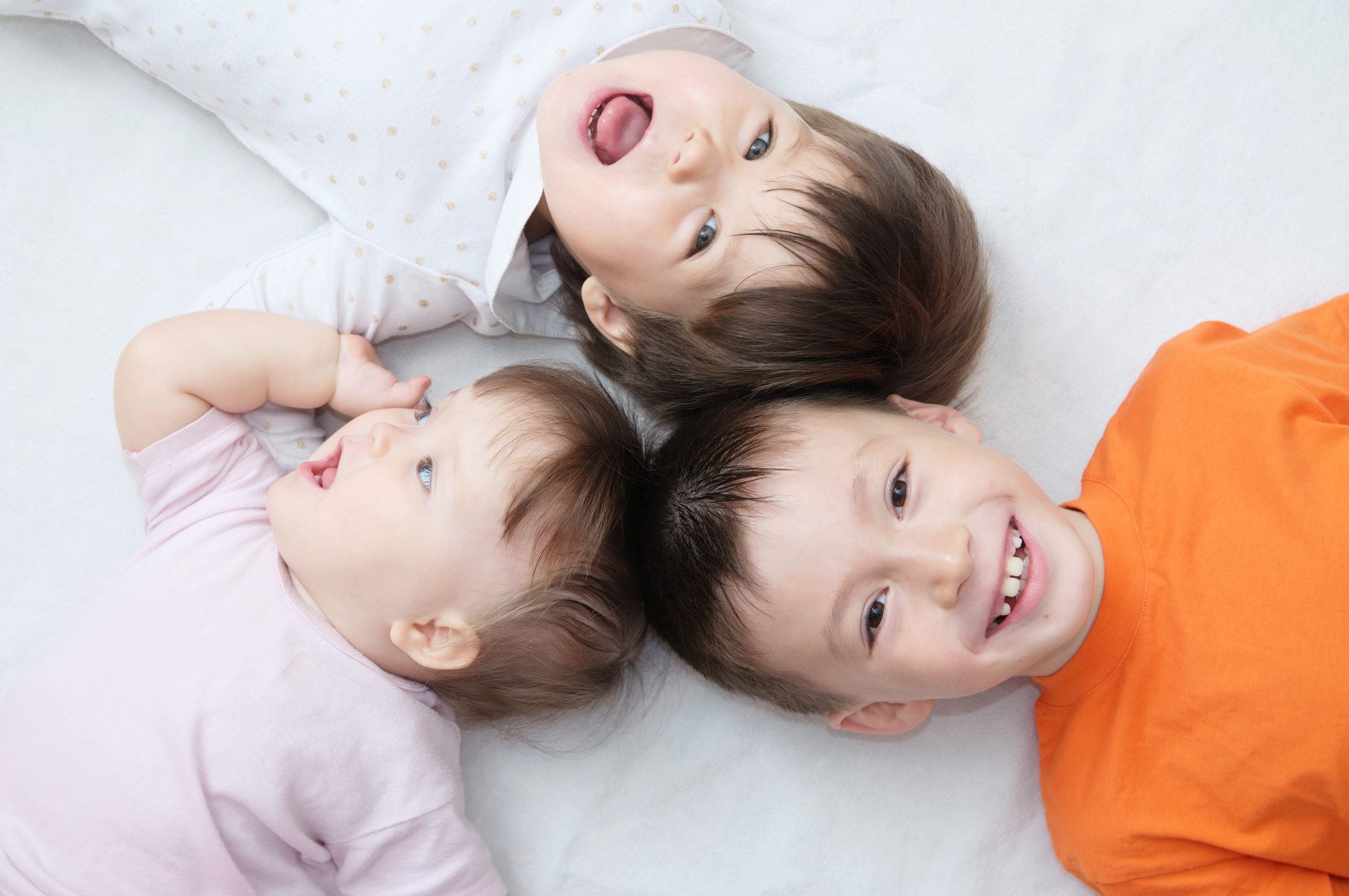happy kids, three laughing children different ages lying, portrait of boy, little girl and baby girl, happiness in childhood of siblings, living in big family enceinte preparation allaitement